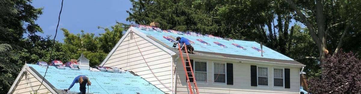 Crew installing a new roof on a suburban home